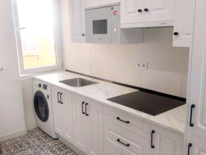 Cocina con puertas de estilo shaker en color blanco y tiradores negros