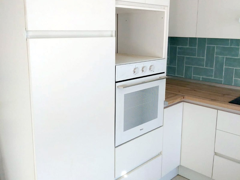 Cocina en forma de U blanca y encimera de madera