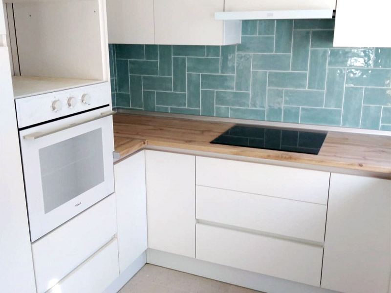 Cocina en forma de U blanca y encimera de madera
