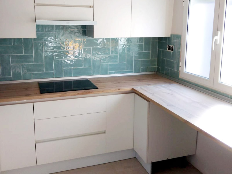 Cocina en forma de U blanca y encimera de madera