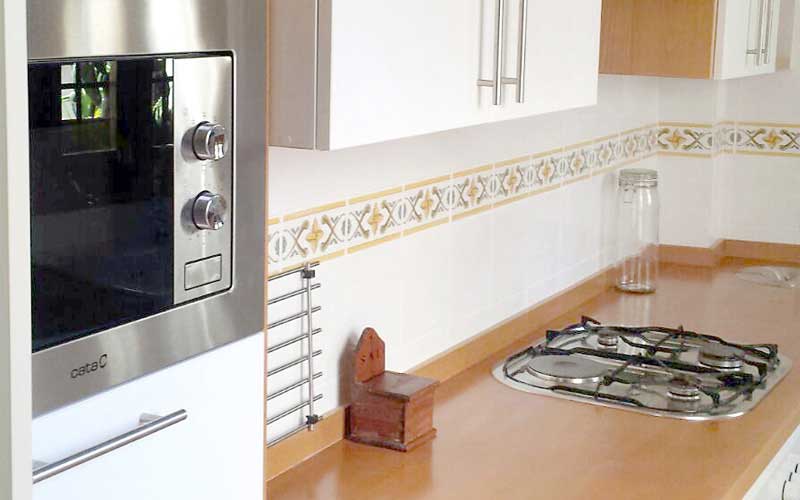 Mueble de cocina blanca y encimera de teka