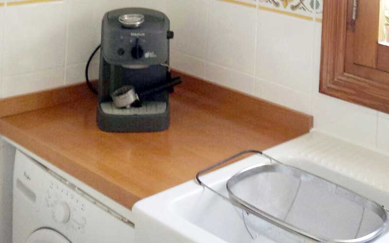 Mueble de cocina blanca y encimera de teka