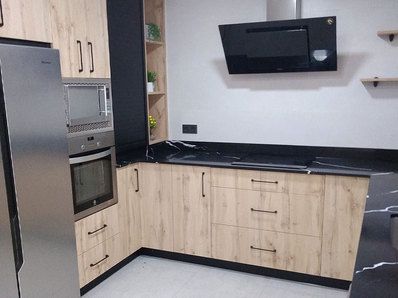 Cocina de color roble y encimera negra con electrodomésticos encastrados