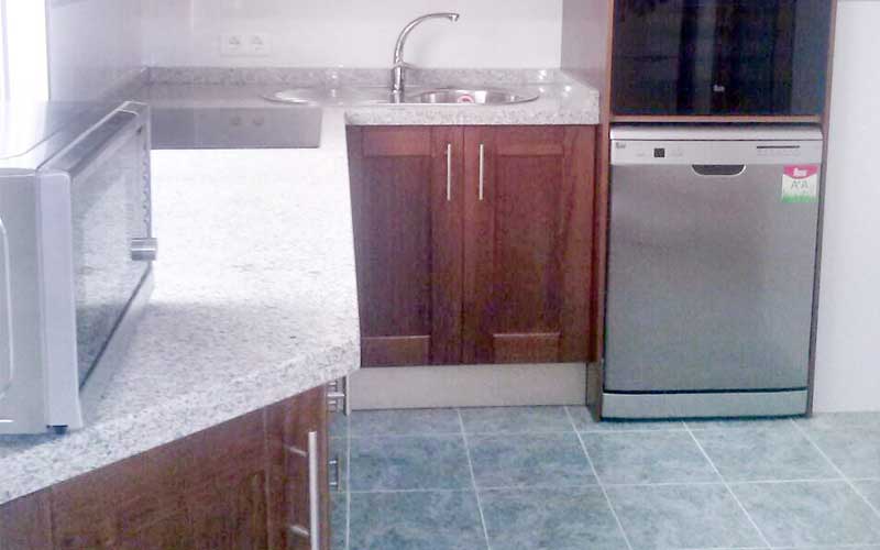 Cocina moderna en tonos oscuros y granito blanco