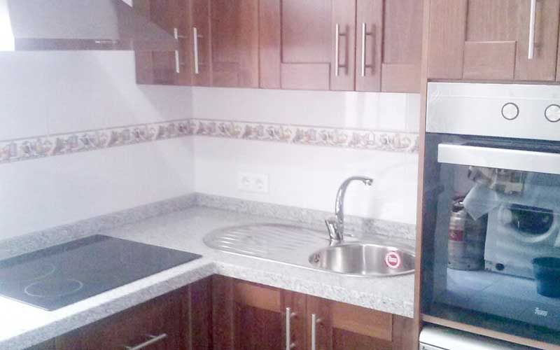 Cocina moderna en tonos oscuros y granito blanco
