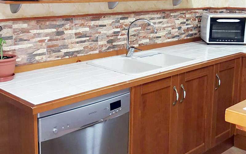 Mueble de cocina rústica y moderna en tono oscuro con encimera de azulejos