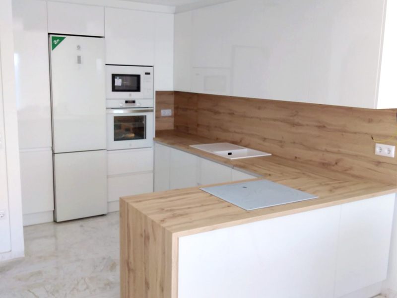 Cocina minimalista de espacio abierto con península en color blanco y madera