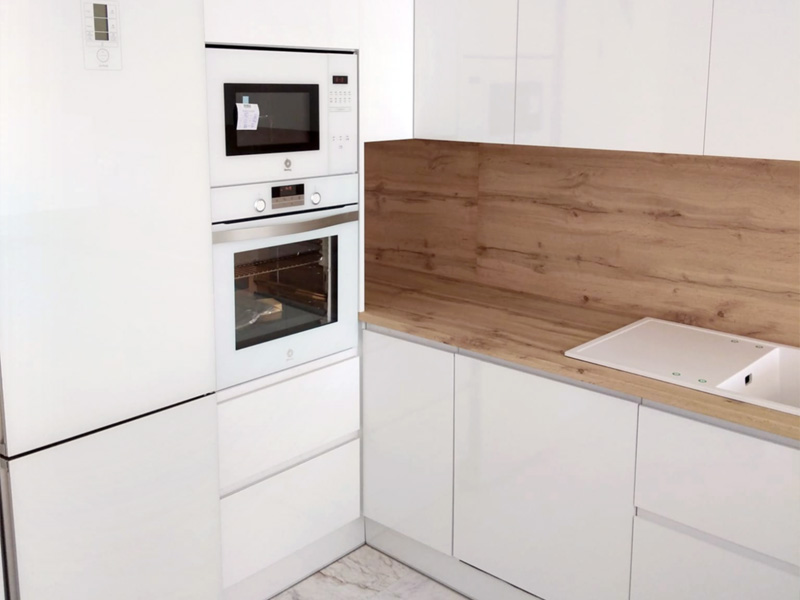 Cocina minimalista de espacio abierto con península en color blanco y madera