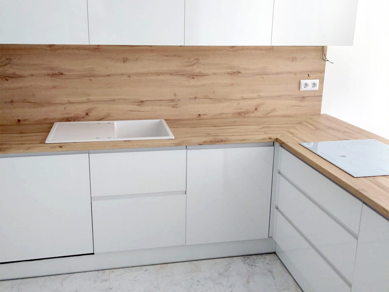Cocina minimalista de espacio abierto con península en color blanco y madera
