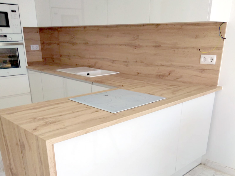 Cocina minimalista de espacio abierto con península en color blanco y madera
