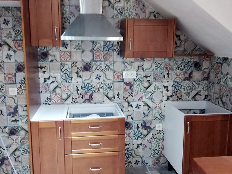 Cocina abuhardillada compuesta de una península y muebles clásicos